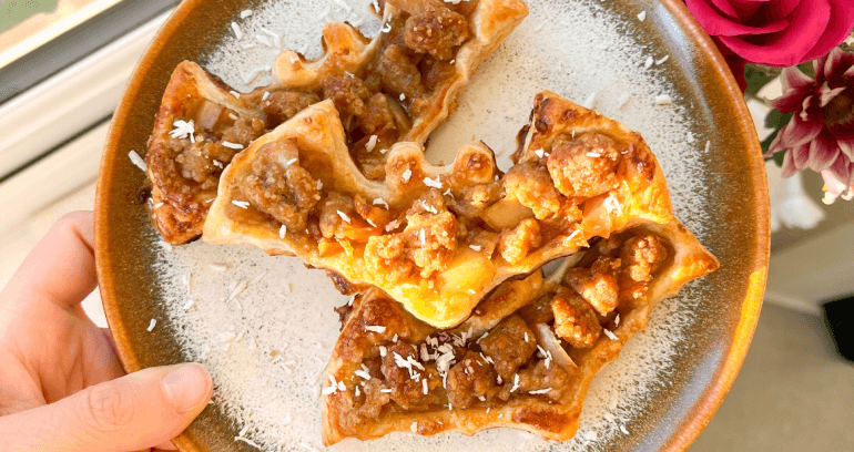 A hand holds a plate of apple crumble bats, showcasing a delicious dessert ready to be enjoyed.