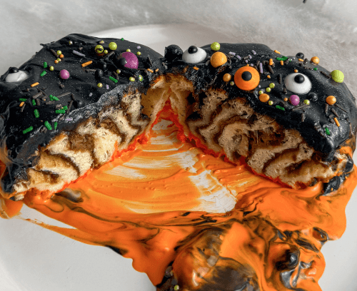 Spooky cinnamon swirls adorned with black and orange icing