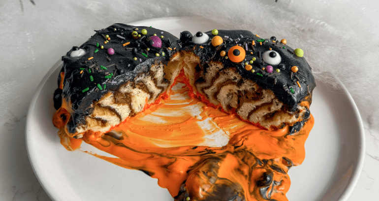 Spooky cinnamon swirls adorned with black and orange icing