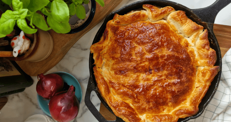 Vegetarian Sausage & Sage Filo Pie in a pan served on a marble top.